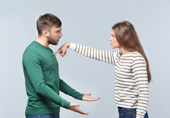 Couple arguing on light background. Problems in relationship