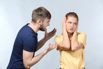 Couple arguing on light background. Problems in relationship