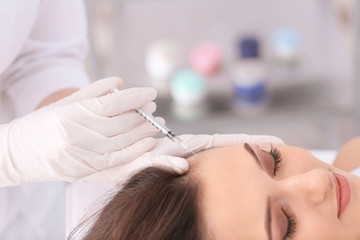Young woman with hair problem receiving injection in clinic, closeup