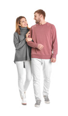 Young couple in casual clothes walking on white background © Africa Studio