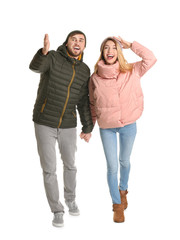 Young couple in casual clothes walking on white background