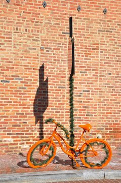 Orange bicycle. The orange bicycle at a brick wall.