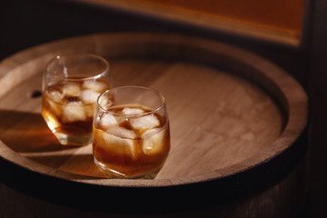 Glass of whiskey on wooden background close up
