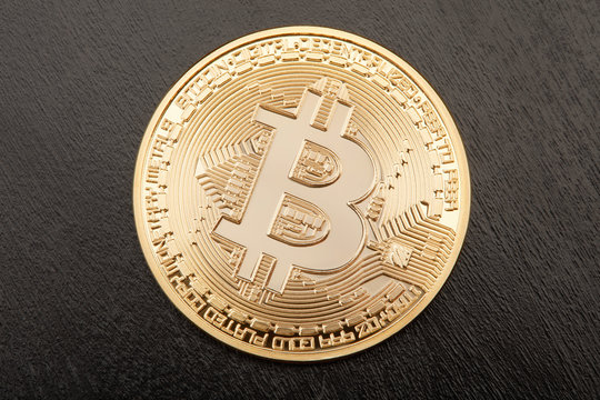 Golden Bitcoin on black wooden table background
