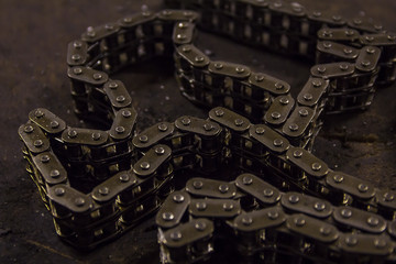 Used sprocket rear chain for ATV, off-road, motobike wheel laying on a repair bench in a repair shop