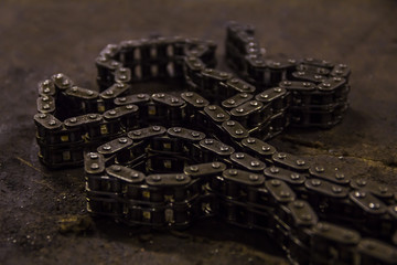 Used sprocket rear chain for ATV, off-road, motobike wheel laying on a repair bench in a repair shop