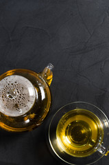 Cup of delicious herbal tea and glass teapot.