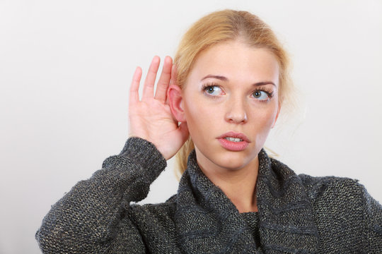 Woman put hand to ear for better hearing