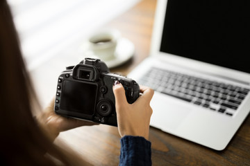 Female photographer with camera at her desk