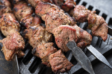 Traditional Russian shashlik on a barbecue skewer as top view on grillage