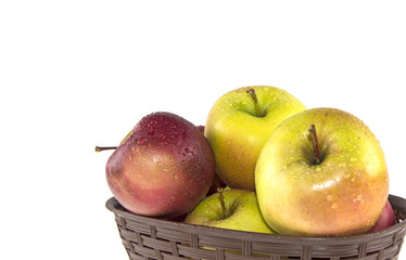 wet apples in a basket on a white background