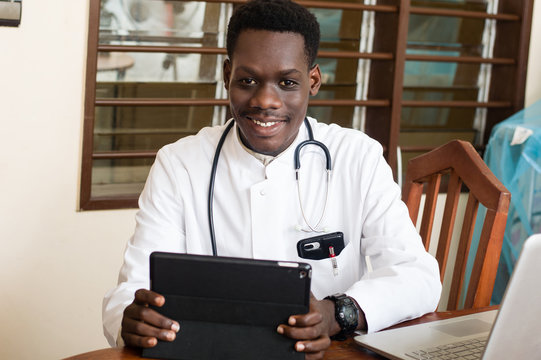doctor with stethoscope and working on a tablet.