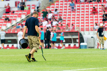 A stadium employee preparing a lawn for the match. agronomist
