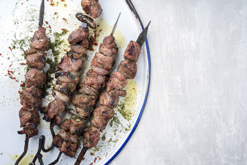 Traditionelle russische Schaschlik Grillspieße   mit Zwiebeln als Draufsicht auf weissen Teller...