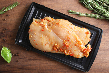 chicken breast in marinade spice, board, rosemary