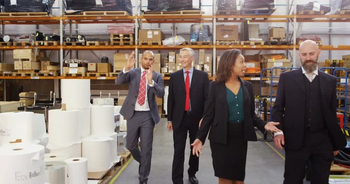4k, Diverse business group walking and talking in a large distribution warehouse.