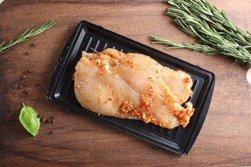 chicken breast in marinade spice, board, rosemary