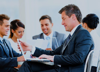 Happy businessman using laptop in business building, smiling.