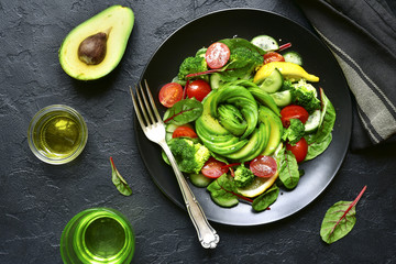 Vegetable salad with avocado, cucumber, cherry tomato, chard leaves and broccoli.Top view with copy space.