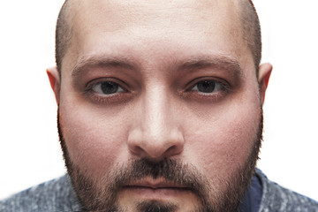 Obraz premium Young man with a bristle is staring or looking intently at the camera, close-up