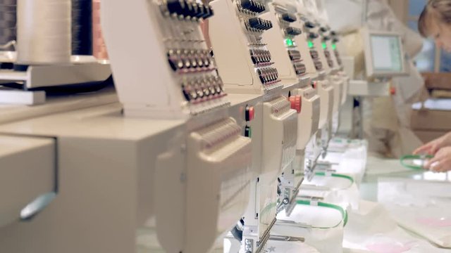 Textile - Professional and industrial embroidery machine. Machine embroidery is an embroidery process whereby a sewing machine or embroidery machine is used to create patterns on textiles.