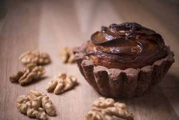 Delicious muffins with nuts placed on a wooden table