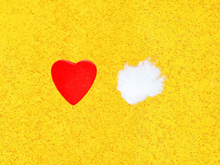 Decorative wooden hot red heart and white cold snow on bright yellow wall background. St. Valentine's Day, melt the ice