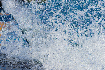 Sunny day at seaside. Sea water splashes at old pier