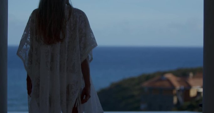 attractive woman walking into light and getting into the swimming pool at villa