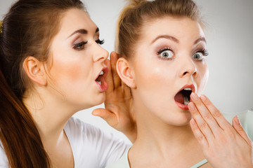 Two women telling gossip