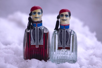 Liqueur from cherries and ouzo in the fun bottles of men with traditional Greek costumes.