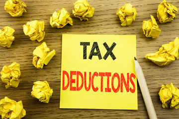 Naklejka premium Word, writing Tax Deductions. Business concept for Finance Incoming Tax Money Deduction written on sticky note paper on the wooden background. Folded yellow papers on the background