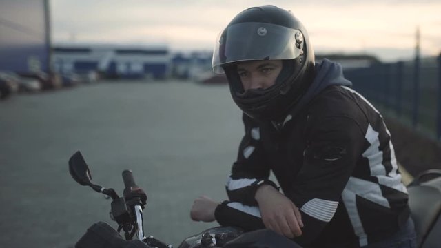 young attractive motorcyclist with black helmet on street. Man motorcycle biker 