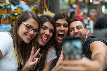 Friends taking a selfie with mobile in a Municipal Market, Sao Paulo, Brazil