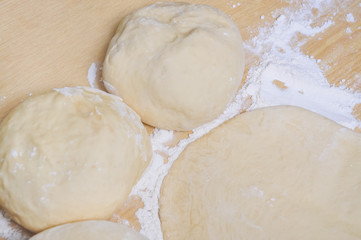 Fototapeta na wymiar Raw wheat yeast dough rolled out into flat cakes on a table