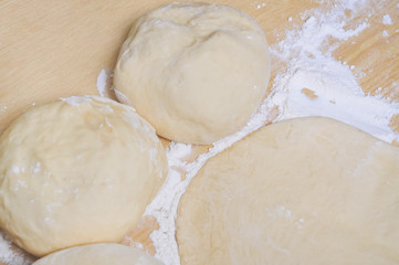 Raw wheat yeast dough rolled out into flat cakes on a table