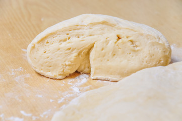 Raw wheat yeast dough rolled out into flat cakes on a table