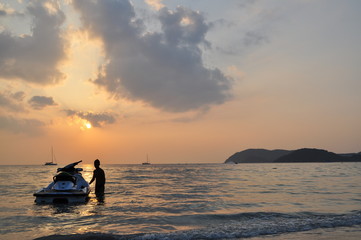 Naklejka na ściany i meble Silhouette of jet ski at Chenang Beach during sunset, Chenang Beach is the most popular beach on the Langkawi island