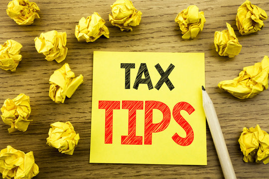 Word, writing Tax Tips. Business concept for Taxpayer Assistance Refund Reimbursement written on sticky note paper on the wooden background. Folded yellow papers on the background