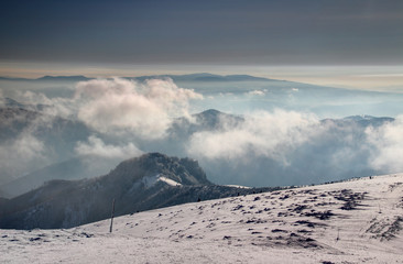 Snow formations and waymarking wooden sticks between Krizna and Majerova skala peaks of Velka Fatra with fluffy low clouds, Polana and Ore Mountains in misty morning light, Carpathians Slovakia Europe © nogreenabove2k