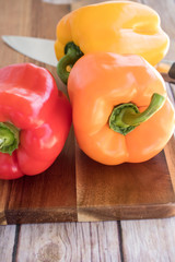 Fresh bell peppers on wooden cutting board