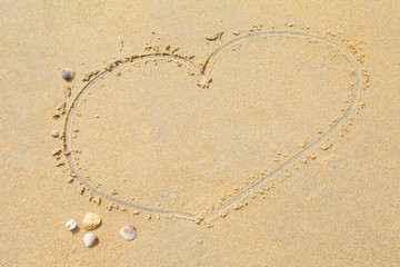 Heart shape drawing on sand beach texture background. Copy space of love and travel concept