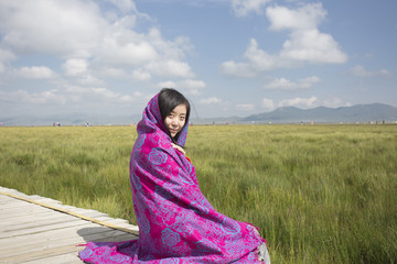 A beautiful woman sitting on the grassland
