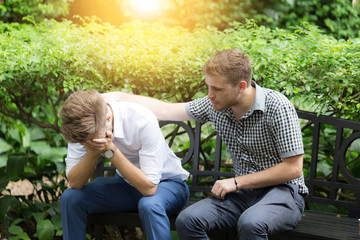 Business man Stressed and Frustrated in the garden and his friend soothe 