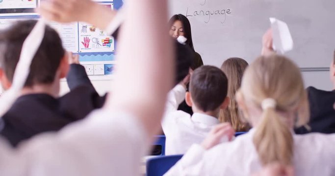 4K Teacher in class has no control over her students, unruly children throw rolled up papers at her. Slow motion