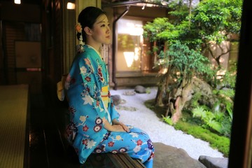 a young Japanese woman is sitting at a traditional Japanese patio