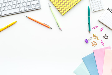 Creative mess on student's desk. Keyboard, notebook, stationery, on white background top view copy space