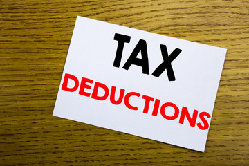 Tax Deductions. Business concept for Finance Incoming Tax Money Deduction written on sticky note, wooden wood background with copy space.