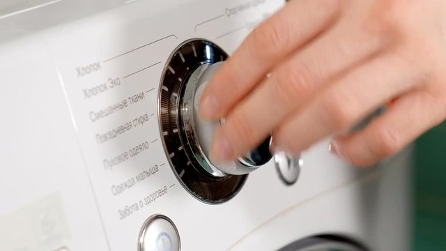 woman adding detergent to compartment in washing machine and closing drawer