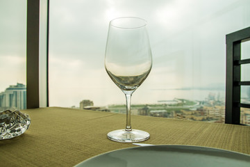 Empty wine glass on the table in front of a window